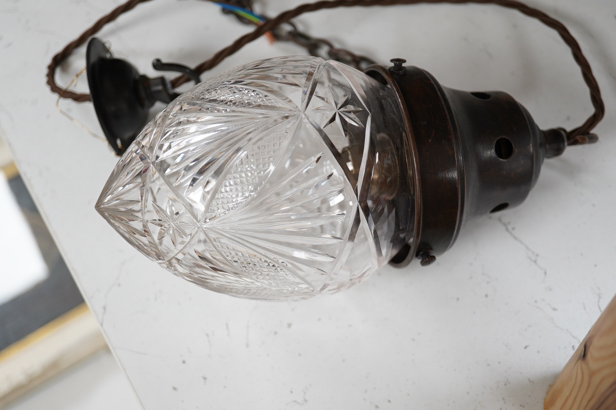 An English cut crystal acorn pendant with gilded bronzed fitting, chain and ceiling rose, wired, glass including gallery 24cm high, 11cm across. Condition - good